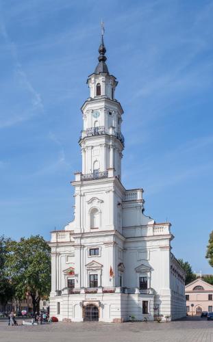 a large white building with a clock tower at Oldtown Trinity House in Kaunas