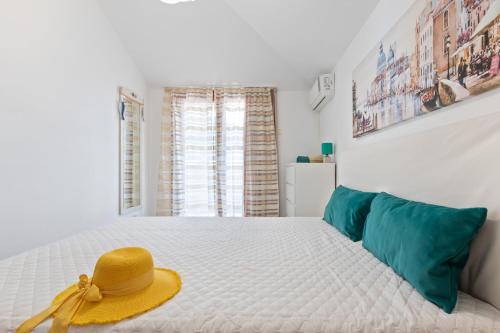 - une chambre avec un lit doté d'un chapeau jaune dans l'établissement Apartment DV Magnolia, à Tivat