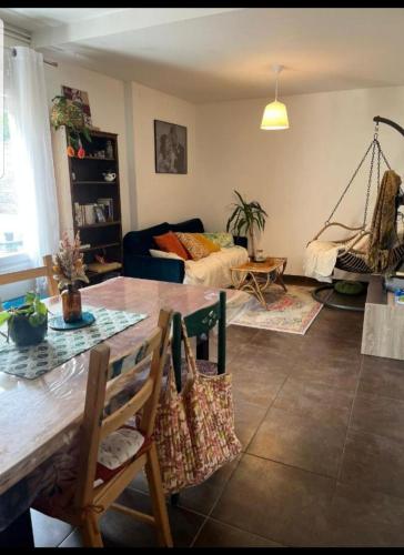 un salon avec une table et un canapé dans l'établissement Chambre proche circuit 4 personnes, au Mans