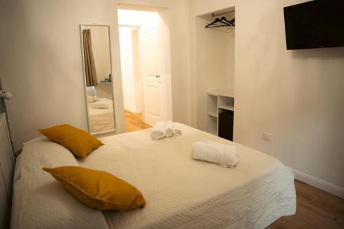 a bedroom with a bed with yellow pillows and a mirror at La Dimora del Generale in Pizzo