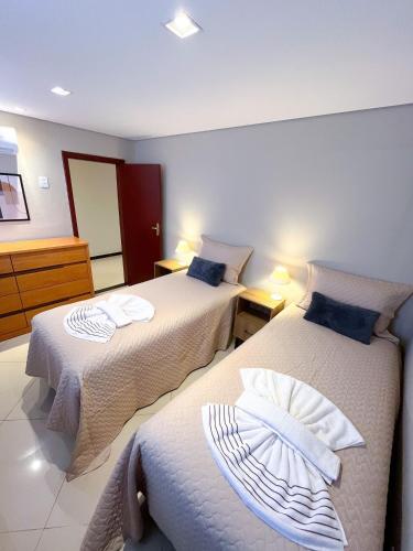 a bedroom with two beds with towels on them at Aconchego do Mercado Velho in Diamantina