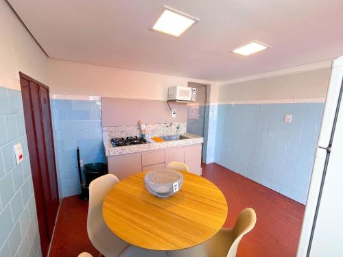 a small kitchen with a wooden table and chairs at Aconchego do Mercado Velho in Diamantina