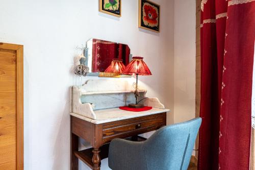 a desk with a lamp and a blue chair at Gîte L'attrape Rêves in Bessans
