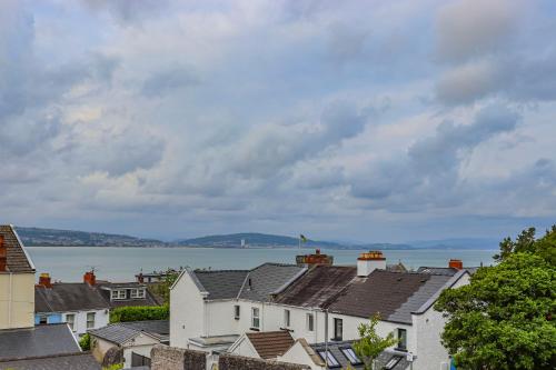 a row of houses with a view of the water at Flo Suite by Koya Homes-3-Bed Home-Parking in The Mumbles