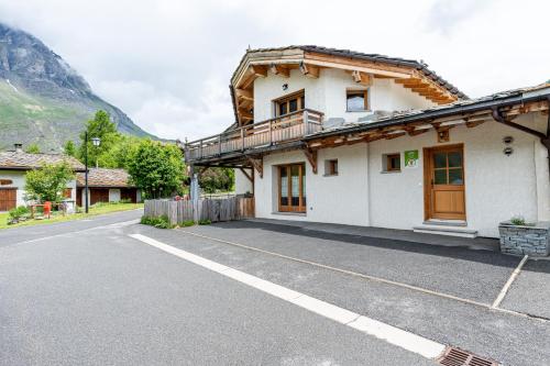 a house with a balcony on the side of a road at Gîte L'attrape Rêves in Bessans