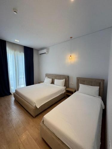 two beds in a hotel room with two beds sidx sidx sidx at Otto Hotel in Ksamil