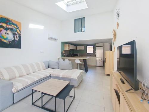 un salon avec un canapé et une télévision dans l'établissement Rognac centre au calme maison entiere 5 couchages et jardin, à Rognac