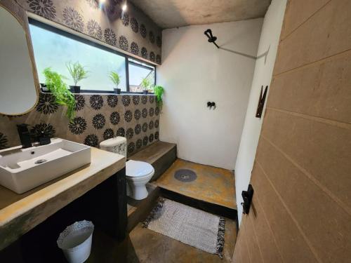 a bathroom with a sink and a toilet and a window at Hartbeest Bush Lodge 27 in Hartbeespoort