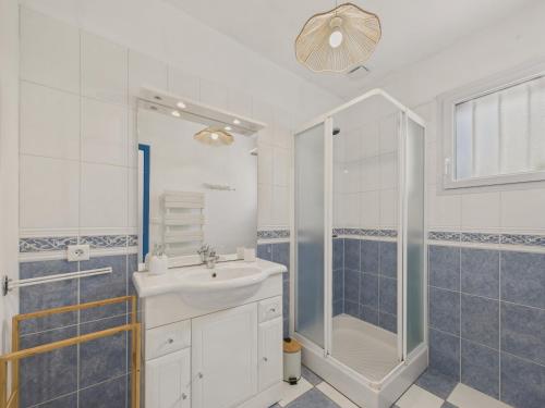 une salle de bain blanche avec lavabo et douche dans l'établissement Jolie maison pour 4 personnes avec jardin, à Saint-Vincent-sur-Jard