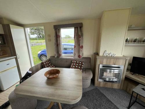 a living room with a table and a couch and a stove at Sea Shanty in Newquay