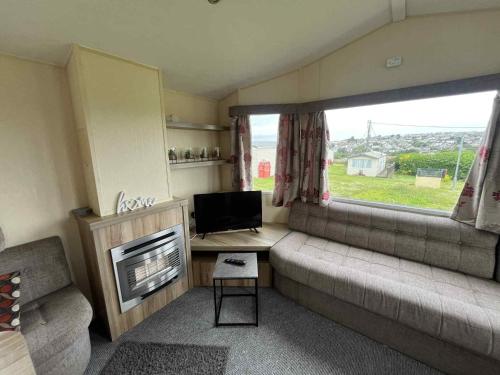 a small living room with a couch and a television at Sea Shanty in Newquay