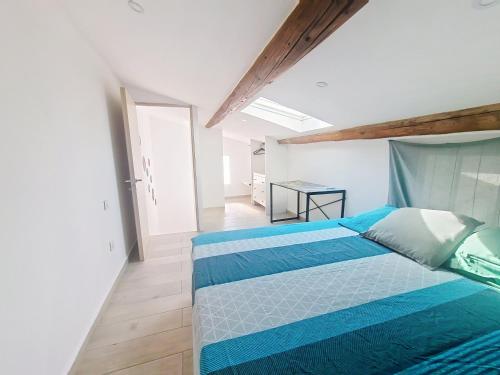 une chambre avec un lit avec des draps bleus et blancs dans l'établissement Rognac centre au calme maison entiere 5 couchages et jardin, à Rognac