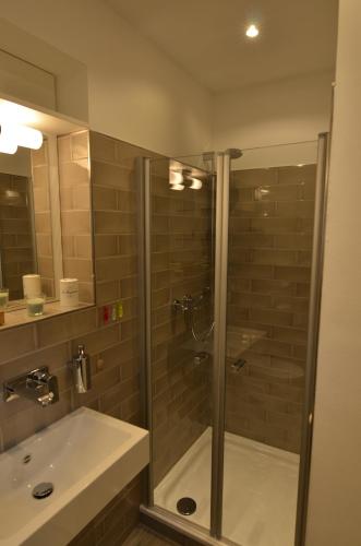 a bathroom with a shower and a sink at Kajüte Holtenau in Kiel