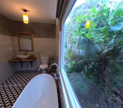 Ấp Long SơnCharm Hon Rom Villas Resort的带窗户的浴室里的浴缸