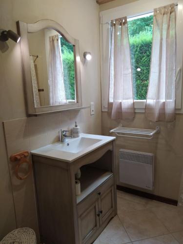 une salle de bain avec un lavabo, un miroir et une fenêtre dans l'établissement Gîte spa privatif, à La Roche-Chalais
