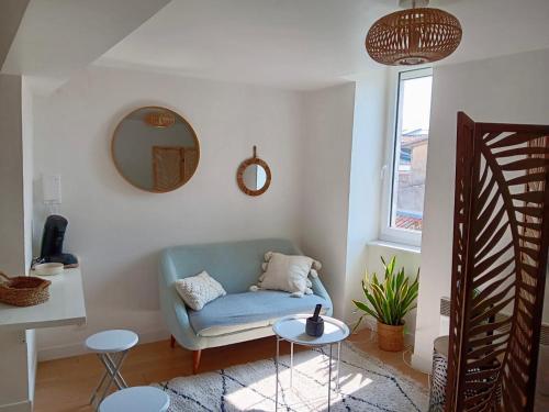 un salon avec une chaise bleue et un miroir dans l'établissement Cosy Space rue des Cloutiers, à La Rochelle