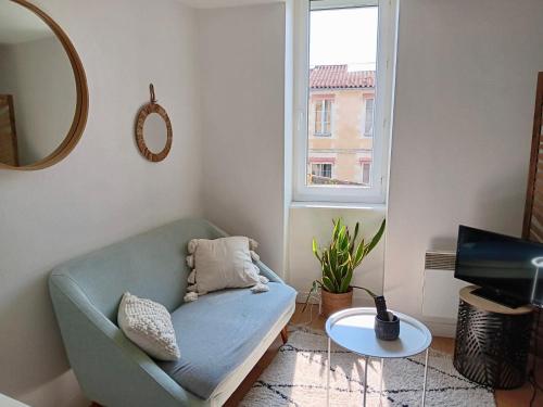 un salon avec un canapé bleu et une table dans l'établissement Cosy Space rue des Cloutiers, à La Rochelle