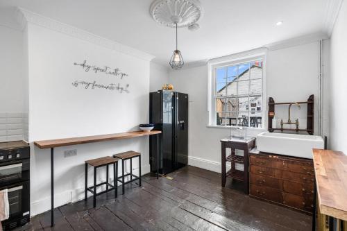 a kitchen with a black refrigerator and a sink at Three Bedroom Townhouse by Primal Estates Short Lets in Brighton in Brighton & Hove