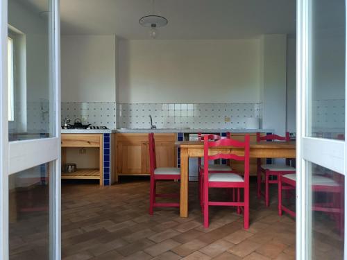 フォリーニョにあるcasaRegina b&b in collinaのキッチン(木製テーブル、赤い椅子付)