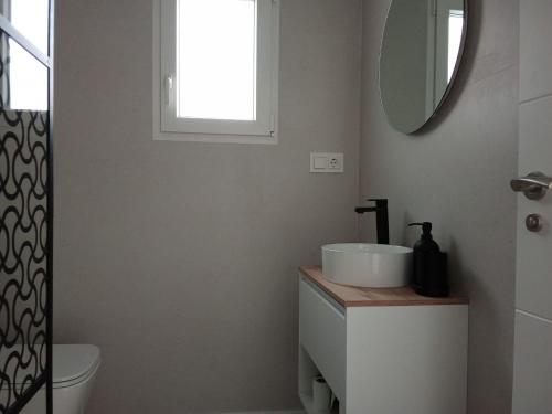 ein Badezimmer mit Waschbecken und Spiegel in der Unterkunft San Pedro del Pinatar Casa Sweeney in Lo Pagán