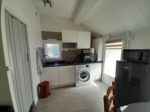une petite cuisine avec un lave-linge et un lave-linge dans l'établissement Charmant studio a Bois le Roi avec parking prive, à Bois-le-Roi