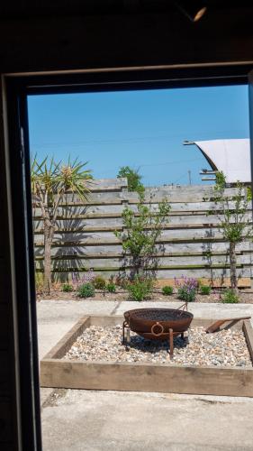 a window view of a bench in a garden at The Potting Barn in Saint Ervan