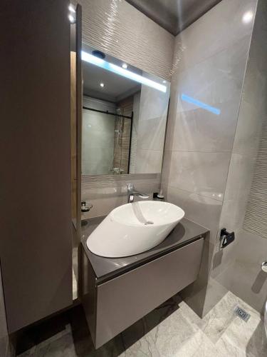 a bathroom with a sink and a mirror at The Diamond In City Luxury Suites By ZENORA Living in Accra