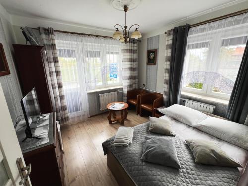 una camera da letto con un letto, una sedia e finestre di AbWentur Pokoje a Danzica