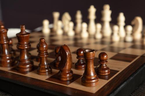 a close up of a wooden chessboard with chess pieces at Wonderland Berwick 5-bedrooms Pet-friendly cottage with the Hot tub in Tweedmouth