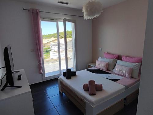 une chambre avec un lit, une télévision et une fenêtre dans l'établissement House in Gard, à Saint-Gervasy