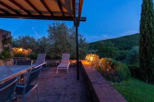 a patio with a table and chairs and lights at Minimal & Modern Home - In Arceno Estate in Villa dʼArceno