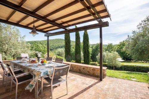 a patio with a table and chairs under a pergola at Minimal & Modern Home - In Arceno Estate in Villa dʼArceno