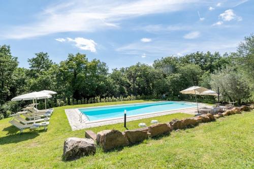 a swimming pool in a yard with chairs and umbrellas at Minimal & Modern Home - In Arceno Estate in Villa dʼArceno