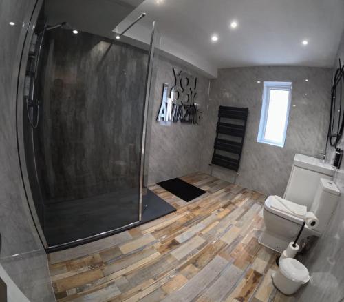 a bathroom with a shower and a toilet at Ellan Vannin Hotel in Douglas