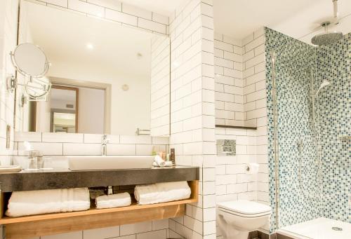 a bathroom with a sink and a tub and a toilet at Holiday Inn Birmingham City by IHG in Birmingham