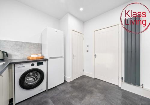 a laundry room with a washer and dryer at Broomfield Apartment by Klass Living Airdrie in Airdrie