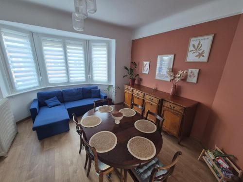 un salon avec une table et un canapé bleu dans l'établissement Appartement en centre-ville à 5mn de la plage, à Calais