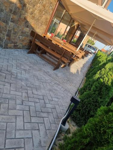 a wooden bench sitting outside of a building at Семеен хотел При Вергил in Sapareva Banya