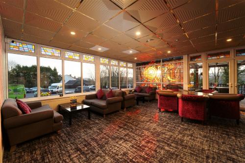 カーマーゼンにあるIvy Bush Royal Hotel by Compass Hospitalityのソファ、椅子、窓が備わる広いロビー
