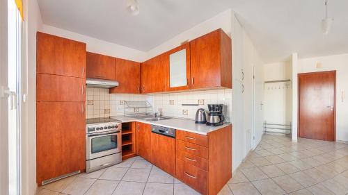 a kitchen with wooden cabinets and a stove top oven at Promenada I, Sun & Snow in Świnoujście