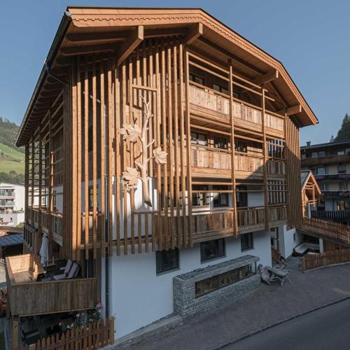 a building with a wooden balcony on the side of it at Atelier Garni Astei in Grossarl