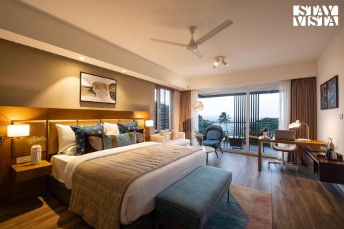 a hotel room with a large bed and a desk at StayVista at Villa Holiva with Pool, Beach View in Silidao