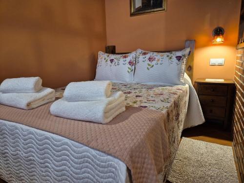 a bedroom with a bed with towels on it at 211A La Chalana Bonito Estudio en Tazones in Tazones