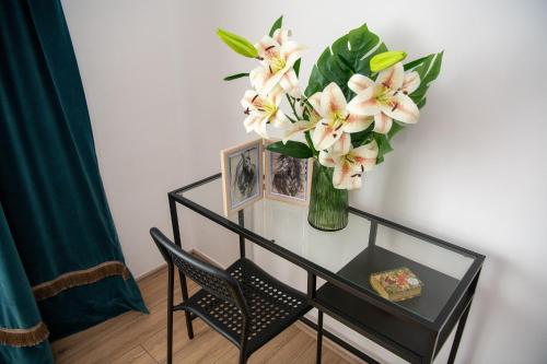 a vase of flowers on a table with a chair at Carska oaza in Lukino Selo