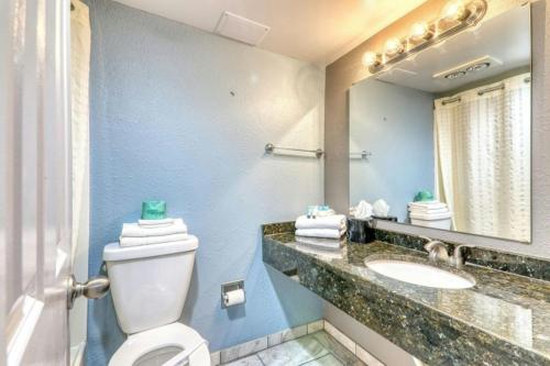 a bathroom with a toilet and a sink and a mirror at Blockade Runner in Myrtle Beach