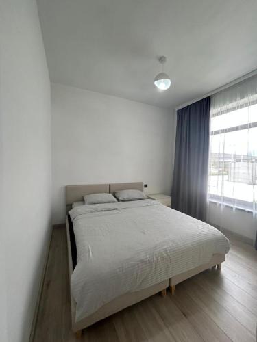 a bed in a bedroom with a large window at Yssyk-kul Palm in Chok-Tal