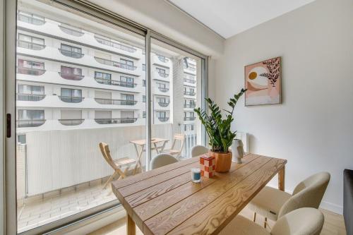 une salle à manger avec une table et une grande fenêtre dans l'établissement Charming apartment near Eiffel Tower 2BR II, à Paris