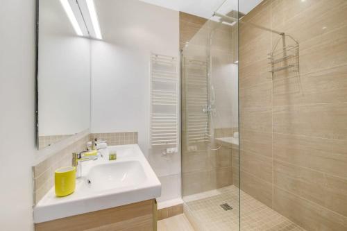 une salle de bain avec un lavabo et une douche en verre dans l'établissement Charming apartment near Eiffel Tower 2BR II, à Paris