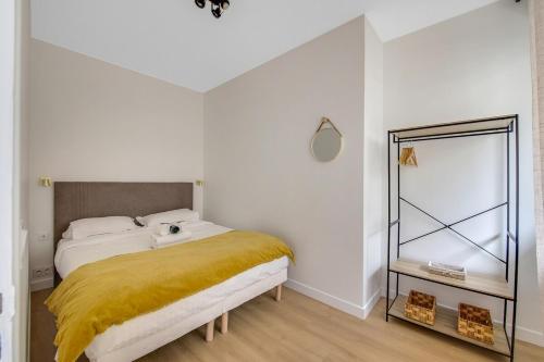une chambre avec un lit avec une couverture jaune dans l'établissement Charming apartment near Eiffel Tower 2BR II, à Paris