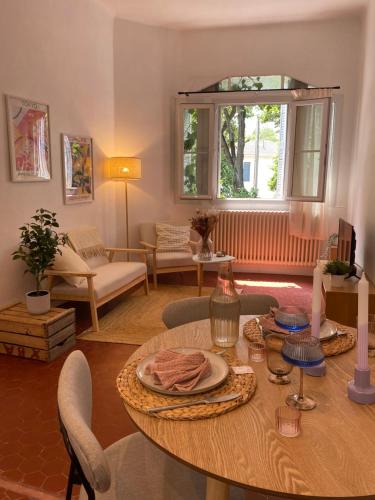 un salon avec une table et des chaises et une fenêtre dans l'établissement Charmant T2 proche Hypercentre, à Avignon
